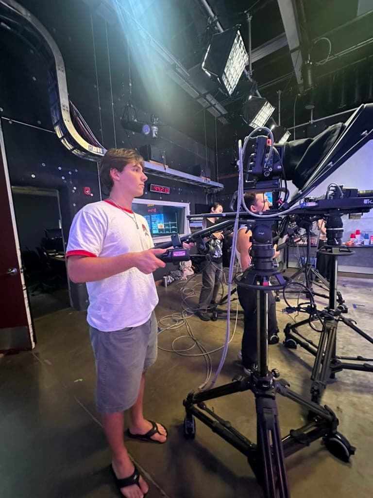 Ben Llados operating a studio camera on the Trojan Vision set